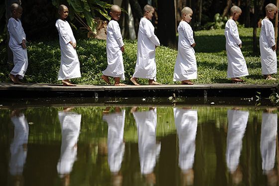 Novice nuns walk in the garden of the Sathira-Dhammasathan Buddhist meditation centre in Bangkok